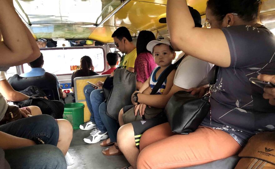 Passengers ride in a jeepney in Manila. Depending on the size, a jeepney can hold up to 20 people. While the vehicles have designated routes, they don't have designated stops, meaning riders hop on and hop off whenever they choose.