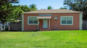 A peach-colored house with a grassy yard in front.
