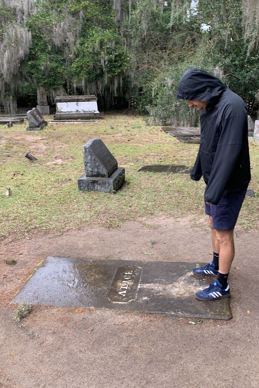 AT Shire looks over the grave marked Alice at All Saints Cemetery near Pawleys Island.