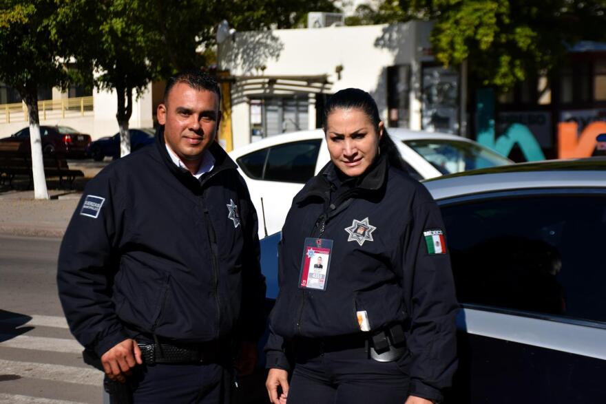 Hermosillo police Officers Luis Moreno and Cristina Garcia stand by a patrol car on Jan. 22, 2020.
