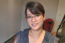 Yerina Ranjit wears a blue polka dotted dress and glasses. She smiles at the camera.