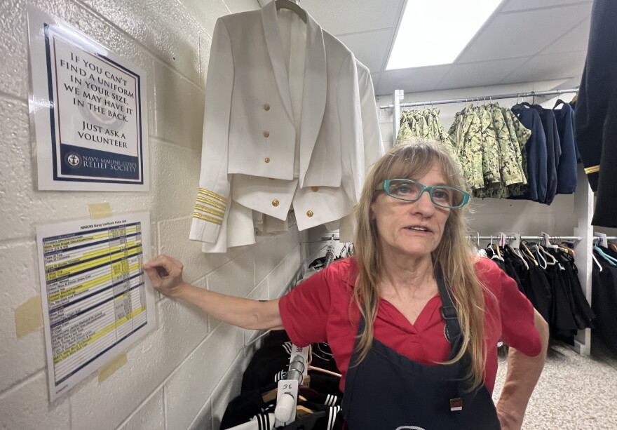 Navy-Marine Corps Relief Society volunteer Faith Carter stands in the military uniform section of the organization’s thrift shop on NAS Pensacola. Carter has volunteered at the shop for three years and helps service members find properly fitting uniforms and other military gear at affordable prices.