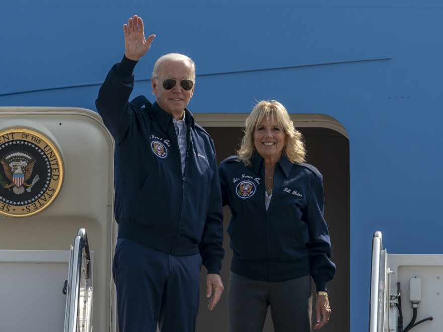 U.S. President Joe Biden waves as first lady Jill Biden watches standing at the top of the steps of Air Force One before boarding at Andrews Air Force Base, Md., Saturday, Sept. 17, 2022.