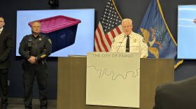 Fargo Police Chief Dave Zibolski, displaying a black tote with a red lid connected to the disappearance and murder of Isadora Wengel.