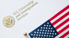 Sobre del Servicio de Ciudadanía e Inmigración de los Estados Unidos con la bandera estadounidense en la parte superior.