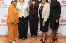 Four women standing in front of a Urban League of Florida Suncoast banner smiling 