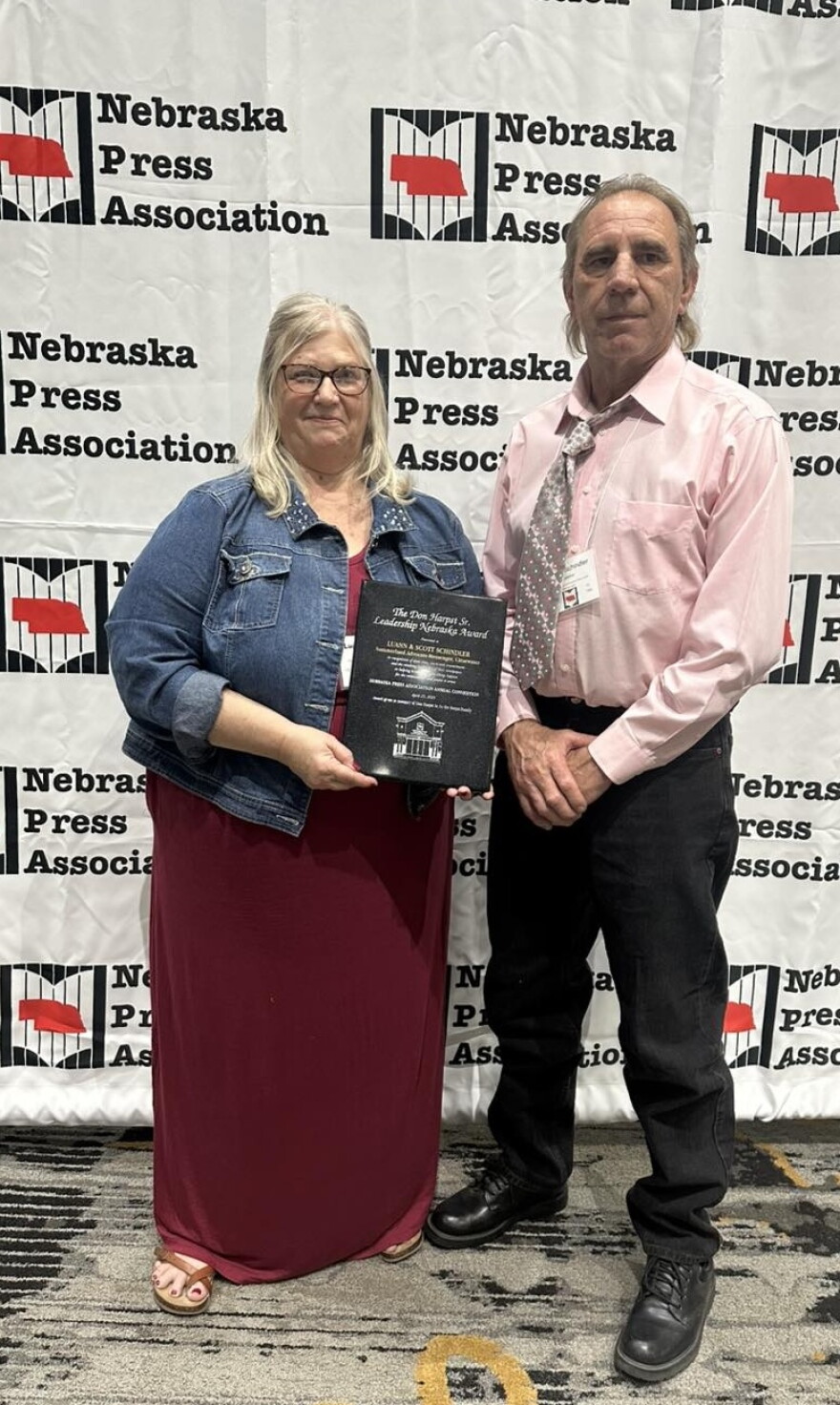 LuAnn and Scott Schindler pose with an award from the Nebraska Press Association on April 26, 2025, in Kearney, Nebraska. The couple owns a local newspaper and a share in a family farm.