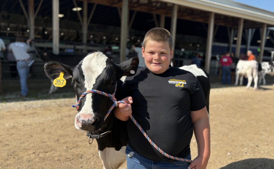 Caden Graham, 11, poses for a photo with his dairy feeder and gets ready for their turn at the competition on Monday, July 21. He says participating in the Isabella County Fair this year means he’ll see lots of his friends.