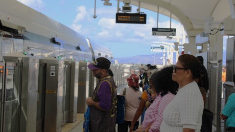 A crowd of people waits for Skyline car doors to open at the Kalihi station for the Middle Street Transit Center, on the opening day of the rail's second segment, Oct. 16, 2025.
