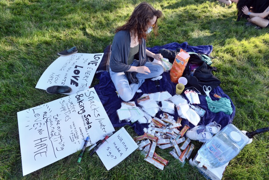 Sadie Mobley arranges snacks and other supplies at her spot near J.C. Nichols Fountain Park on Sunday. Mobley said she protested the first two days, but she wanted to come out Sunday to help out as much as she could. "It's beautiful to see everyone so empathetic," she said.