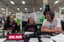 KAXE Morning Show producer Jennifer Barr, left, Director of Content and Public Affairs Heidi Holtan, and volunteer Mark Klabunde chat during an interview broadcast live Aug. 28, 2026, from the Minnesota State Fair.
