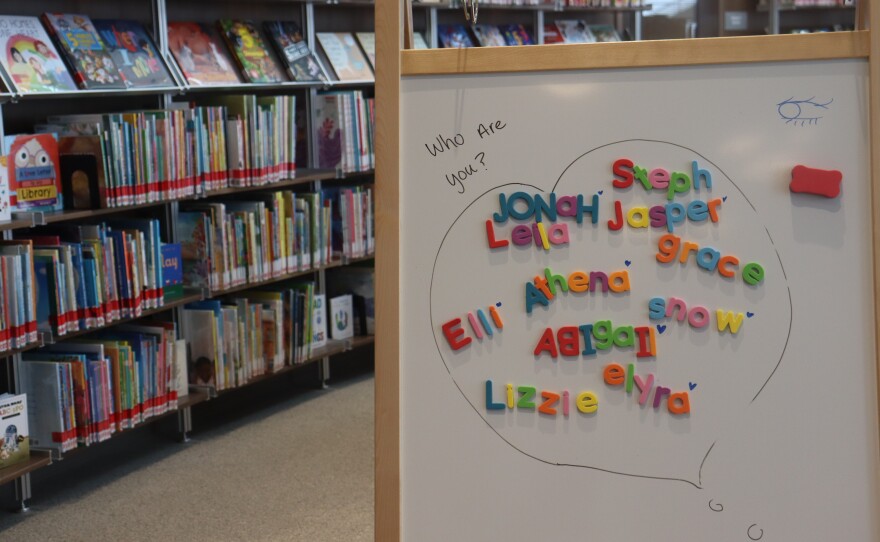 A white board with children's names spelled out with colorful magnetic letters