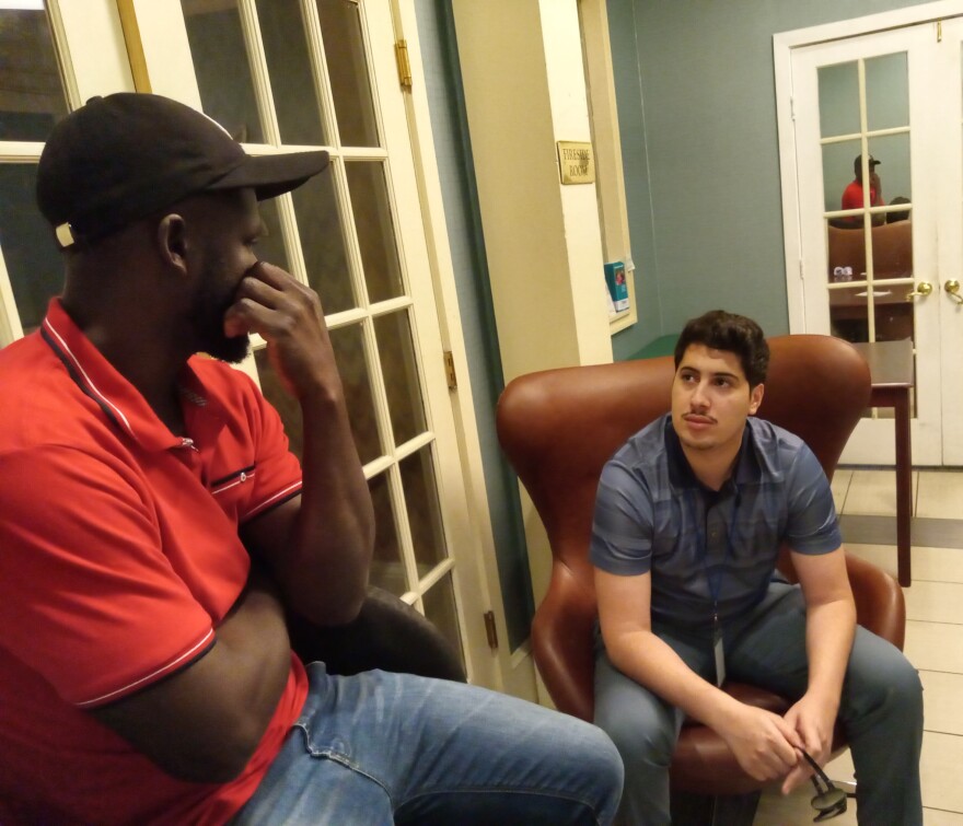 Frantzset Valcius, left, is the father of two West Springfield Public School students. He is speaking with Morad Majjad, right, a family liaison with the West Springfield Public Schools, at a hotel that has become an emergency shelter for families without housing. Valcius and his family are Haitian and are living in a state emergency shelter run out of a West Springfield hotel.