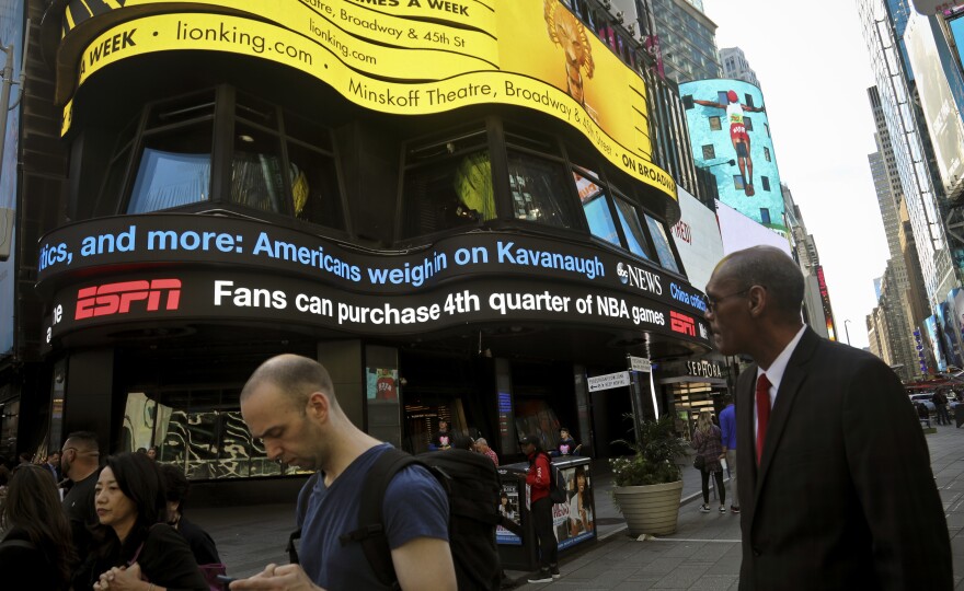 A news ticker in New York City's Times Square shows headlines about the Senate Judiciary Committee hearings.