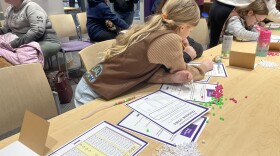 8-year-old Stella Mae Easton, Girl Scout, working on a Binary Code bracelet