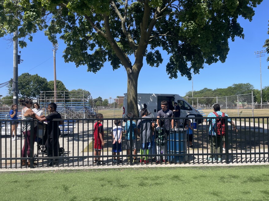 Kids line up for free summer meals distributed at Burnham Park on Milwaukee's South Side on July 29, 2026. Hunger Task Force provides the free meals five days a week in summer at 170 distribution sites across the city. When the truck arrives, Hunger Task Force partner Willie Wilson says there's always an excited line of children waiting.