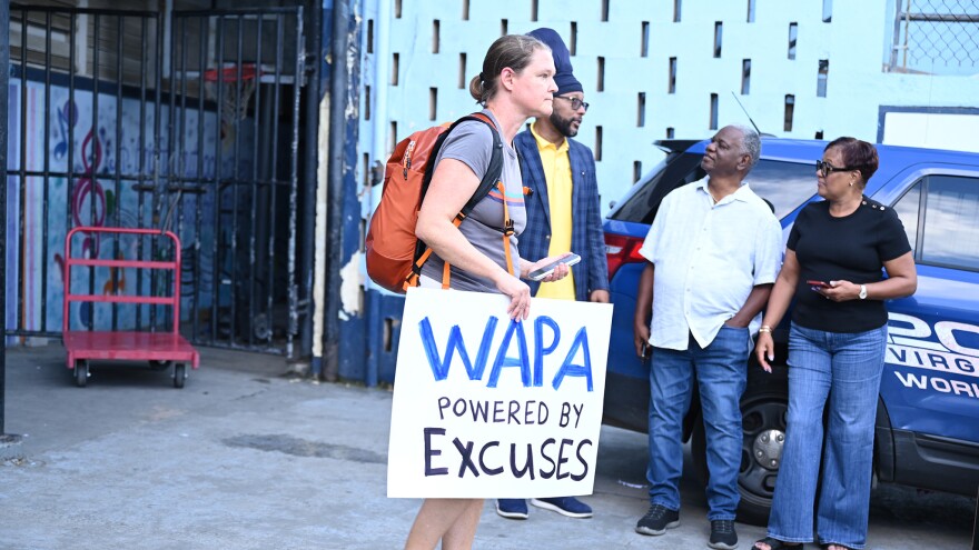 Pictured: A protester stands outside the Julius E. Sprauve School on St. John, where the Virgin Islands Water and Power Authority held a Town Hall on St. John last night.