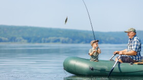 grandfather with grandson fishing from inflatable boat