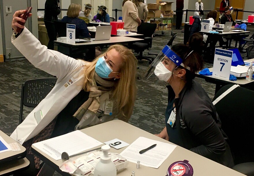 Washington University School of Medicine director of clinical trials Marci Damiano (left) snaps a selfie after receiving a coronavirus vaccination from nurse practitioner Christy Kay.