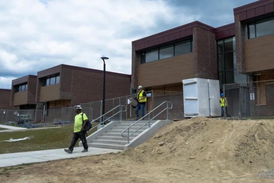 Construction workers exit Windham High School. The high school project was one of the school renovations where state officials encouraged local officials to hire either AAIS or Bestech, two demolition and hazmat contractors.