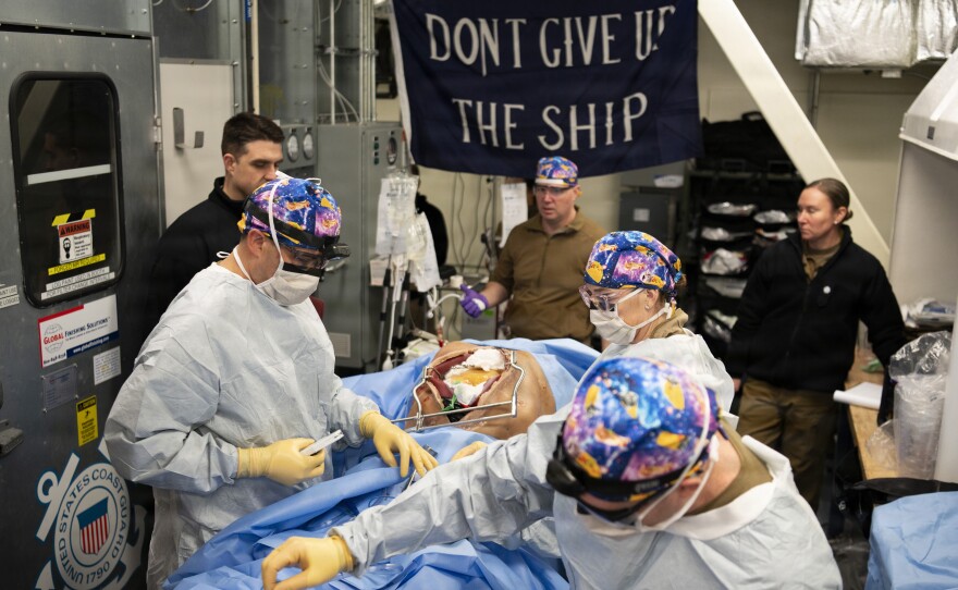 U.S. Navy Cmdr. Michelle Miller (right), an emergency medicine nurse assigned to Expeditionary Resuscitative Surgical System Team 3, and U.S. Navy Cmdr. Kyle Checchi (left), a surgeon assigned to ERSS Team 3, operate on a patient simulator as part of a ship-to-shore patient transfer during ARCTIC EDGE 2026 at Kodiak, Alaska, Feb. 24, 2026.