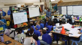 Malama Honua charter school students are trying to solve a math problem from inside of a barn.