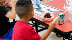 A pre-kindergarten student eats a peanut butter and jelly sandwich during "third meal" at Whitebead Public Schools.