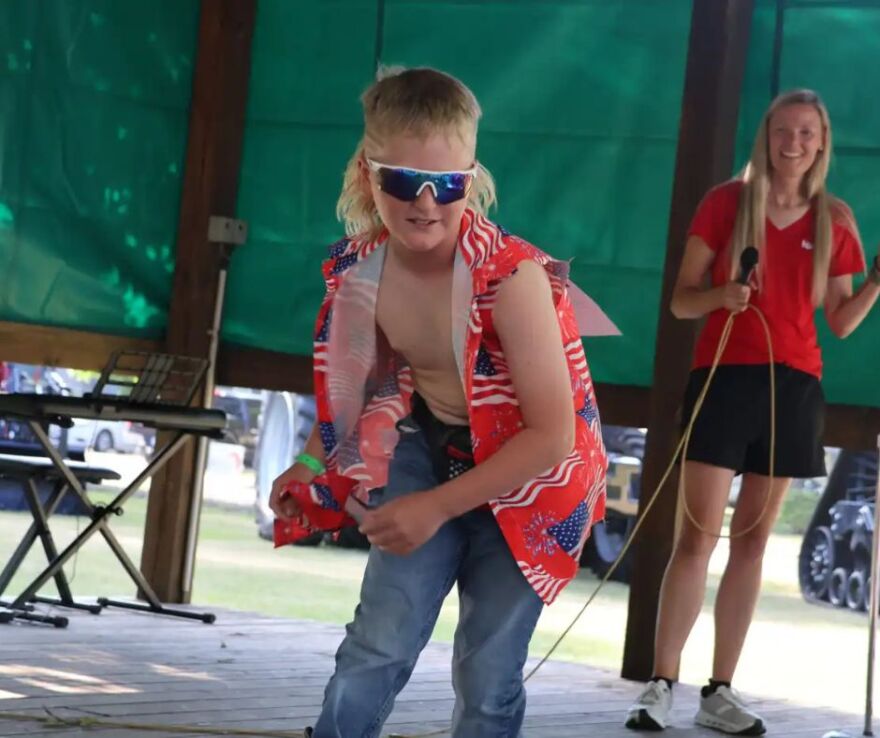 Reed Moszer takes off his bandana and tosses it to the ground at the Clay County Fairgrounds | MPR News