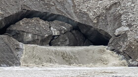 Meltwater is gushing from the mouth of the Castner Glacier ice cave, carrying chunks of ice, rocks and other debris that's turned Castner Creek into a torrent.