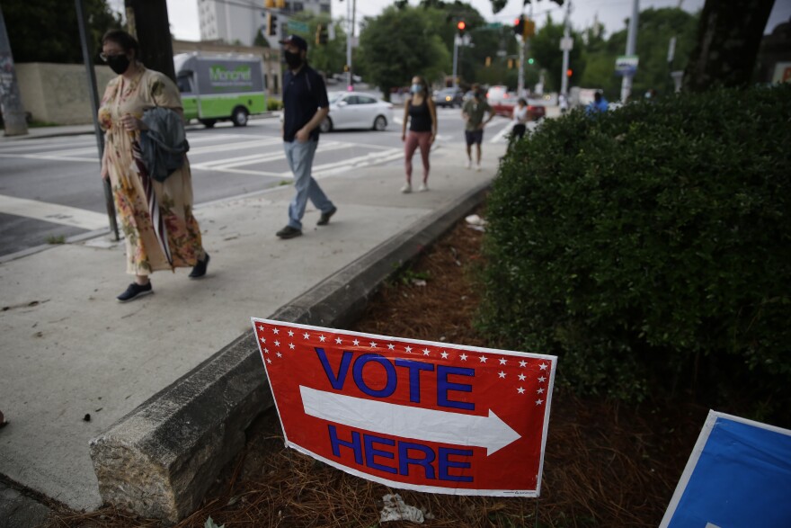 People wait in line to vote in Georgia's primary election in Atlanta on Tuesday. Long lines and equipment problems are hampering the twice-delayed primary.