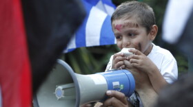 A young Syrian who lives in Greece shouts slogans during a protest outside the Syrian embassy in Athens, Tuesday, Aug. 2, 2011. About 80 people gathered outside the embassy as Syrian troops killed nearly 100 people in two days, firing at worshippers heading to Ramadan prayers in the city on Hama, an opposition stronghold.