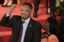 FILE - Rev. Jesse Jackson gestures to a friend in the balcony at the 16th Street Baptist Church in Birmingham, Ala., Sept. 15, 2013. The church held a ceremony honoring the memory of the four young girls who were killed by a bomb placed outside the church 50 years ago by members of the Ku Klux Klan. At right is U.S. Rep. Terri Sewell, D-Ala. (AP Photo/Dave Martin, File)
