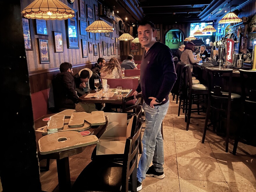 Pub co-owner Leon Teterin, born in Russia, displays the wooden letters he removed from the pub's sign.