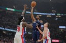 Cleveland Cavaliers' Donovan Mitchell, center, shoots between Detroit Pistons' Isaiah Stewart (28) and Duncan Robinson, right, in the first half of Game 4 of a second-round NBA basketball playoff series Monday, May 11, 2026, in Cleveland. 