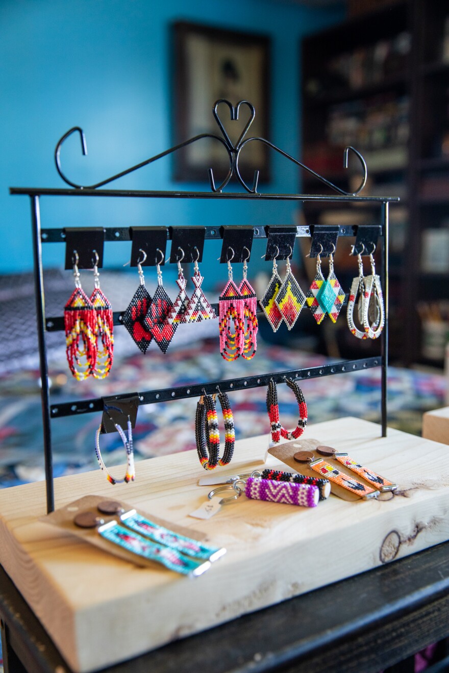 Beaded earrings are displayed on a jewelry rack. They are made by Bonnie Murphy, an indigenous jewelry maker from the Mi'kMaq nation in Houlton, Maine. They are each made of various colored beads.