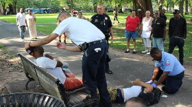First responders seek to revive victims passed out on the Upper Green mid-afternoon on Wednesday.