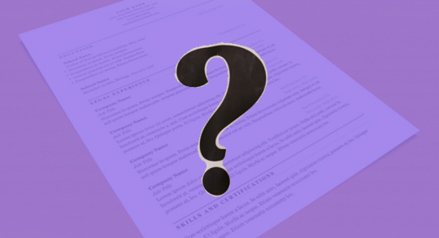 Question mark with a purple background of a piece of paper on a flat surface