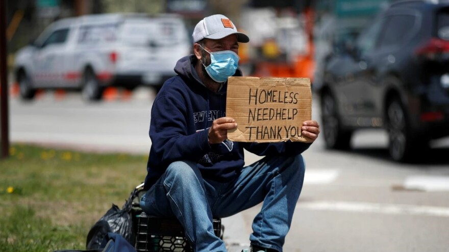 A homeless man wears a mask while panhandling May 15, 2020.