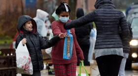 Volunteers from the Baltimore Hunger Project pass out food to people in need outside of Padonia International Elementary school on December 4, 2020 in Cockeysville, Maryland. (OLIVIER DOULIERY/AFP via Getty Images)