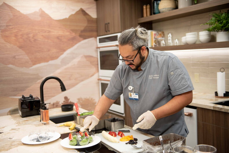 A chef prepares food at Thomas Cuisine.