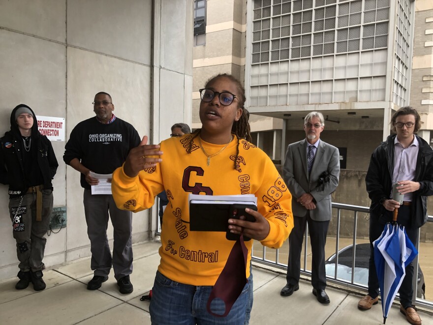 Daj'za Demmings speaks to a crowd outside a government building in downtown Dayton. She is a member of the Montgomery County Jail Coalition, and they are demanding the county release plans for it's new, bigger jail.