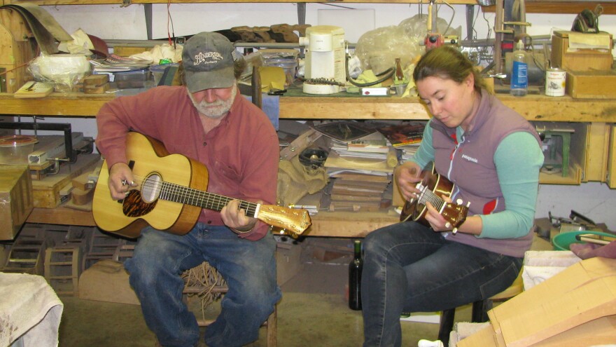 Jayne Henderson (right) and her dad, Wayne Henderson, test out a guitar and a ukulele in Wayne's shop in Rugby, Va.
