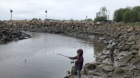 Two small children fishing in a narrow slough