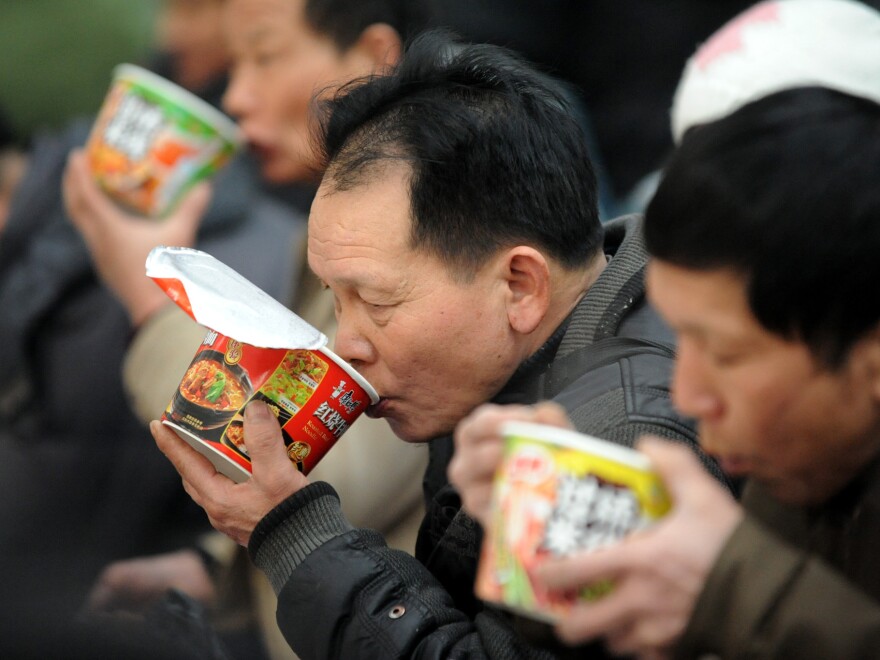 Passengers eat instant noodles at the railway station in Shenyang, China in January 2013.