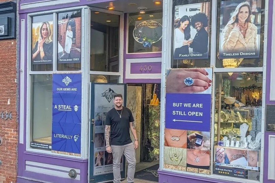 Cole Whipple stands in the Park City Jewelers storefront, with signs making the most of the recent break-in.