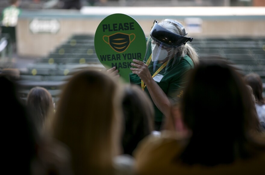 A Coliseum service employee carries a mask through the stands reminding fans to wear as mask in this photo from June 4, 2021. California's statewide mask policies ended as of Saturday, March 12, 2022.