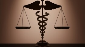 Medical Caduceus Symbol as Scales with backlight over Wall in dark room.