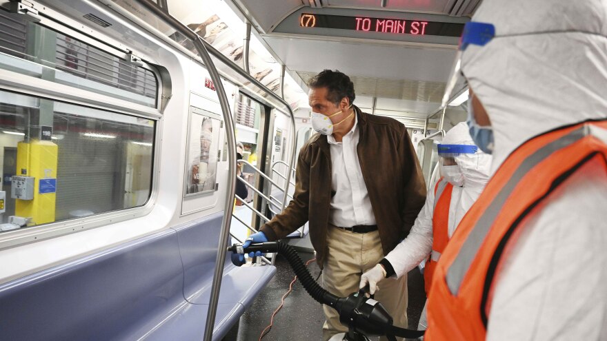 Gov. Andrew Cuomo tries out a spraying device on a New York City subway car during a visit to the Metropolitan Transportation Authority on Saturday.