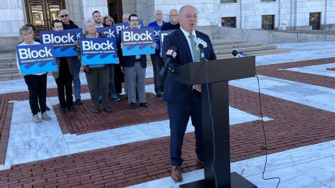Independent gubernatorial candidate Ken Block speaks at a news conference outside the Rhode Island State House in Providence on Monday, Oct. 26, 2026, as supporters stand behind him. Block outlined 17 policy priorities and pledged not to undermine the Affordable Care Act if elected governor. Credit: Ian Donnis/Ocean State Media