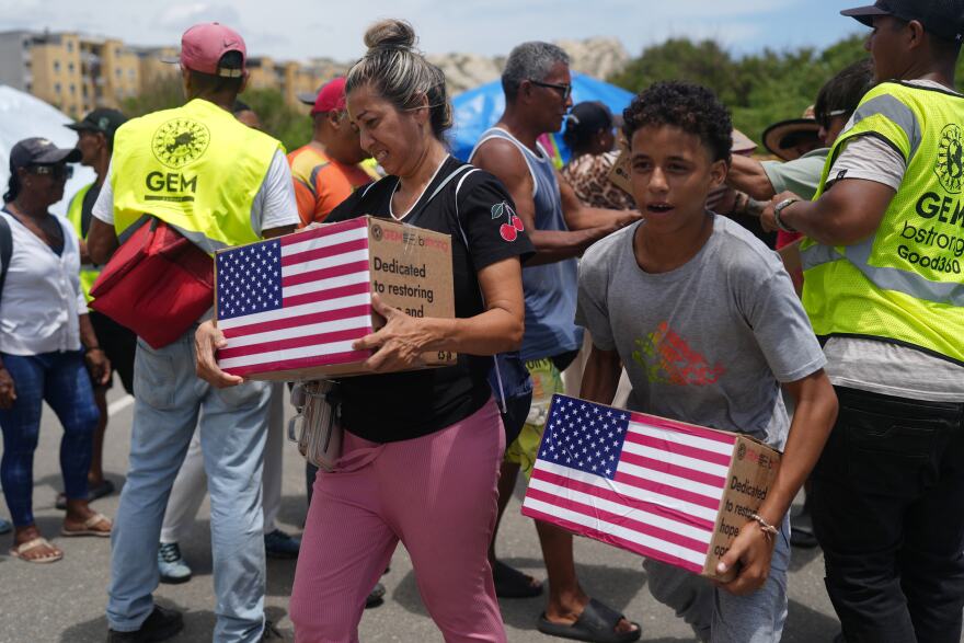 People affected by the earthquakes carry U.S. humanitarian aid after receiving it in La Guaira, Venezuela, Wednesday, July 8, 2026. 